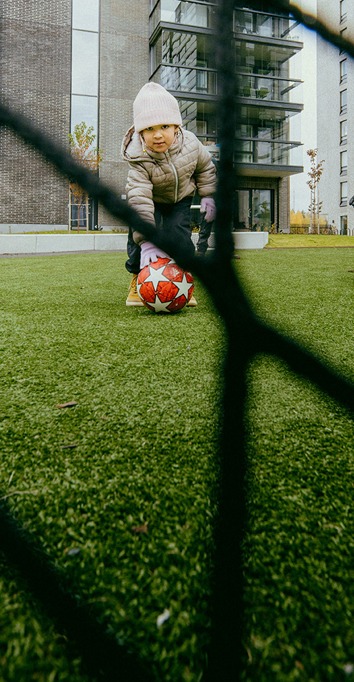 a child is kicking the footbaal into the goal