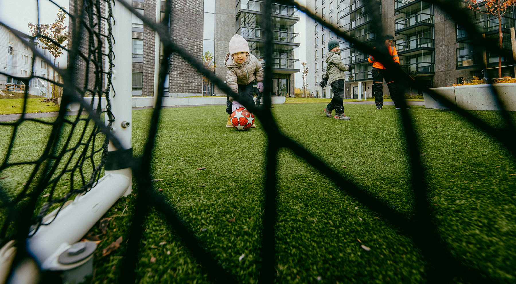 a child is kicking the footbaal into the goal